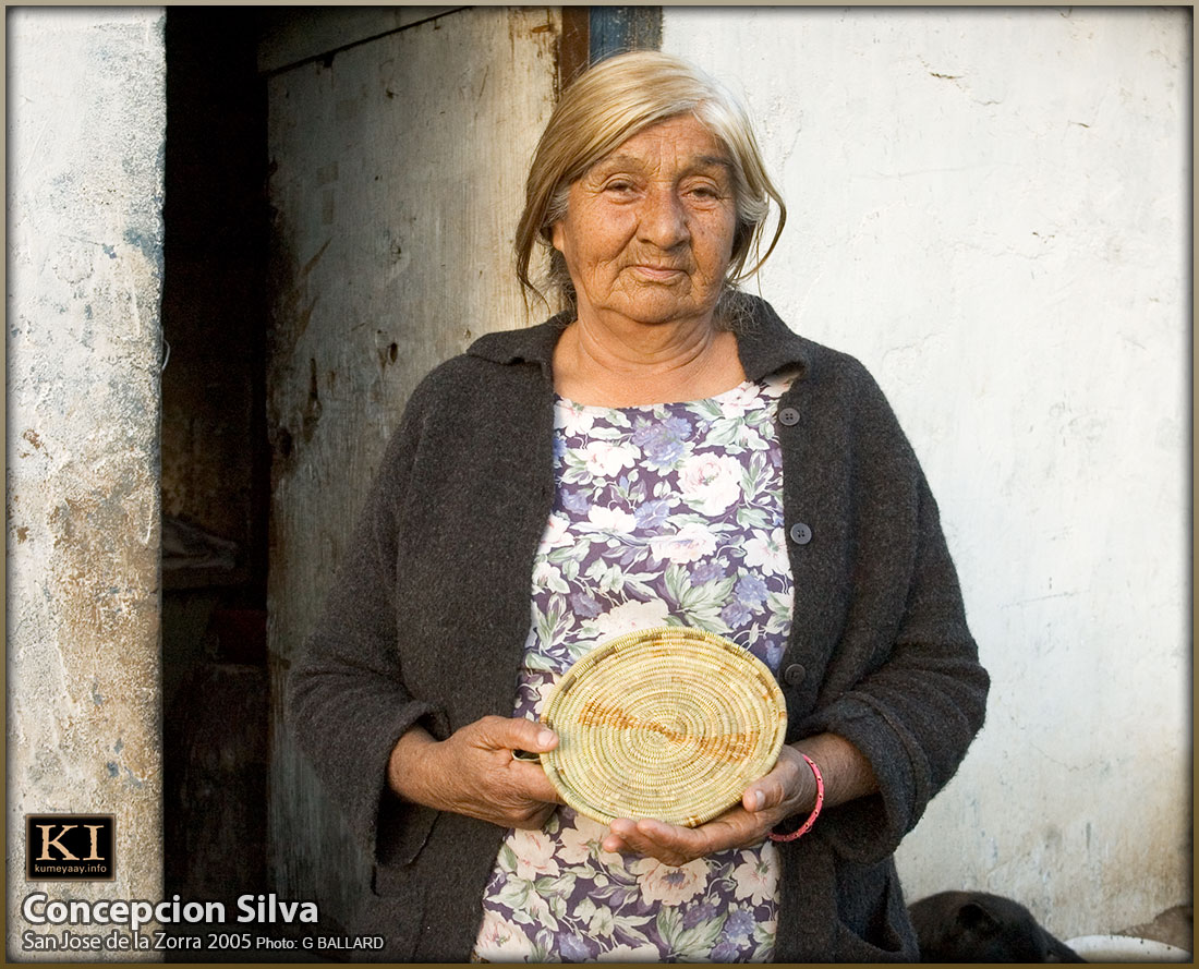 Concepcion Silva displays one her juncus baskets on the front step of her Kumiai Indio home on the San Jose de la Zorra indigenous ejido, Mexico
